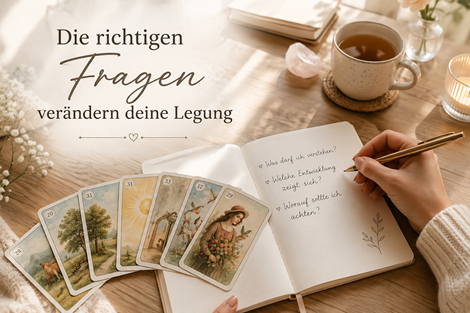 Eine helle, ruhige Szene auf einem Holztisch. Darauf: aufgefächerte Lenormandkarten , ein geöffnetes Journal mit handgeschriebenen Fragen, eine Tasse Tee , sanftes Tageslicht, eine nachdenkliche Frauenhand mit Stift